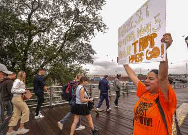 Protester against Trump stands outside US Open final during president's appearance.