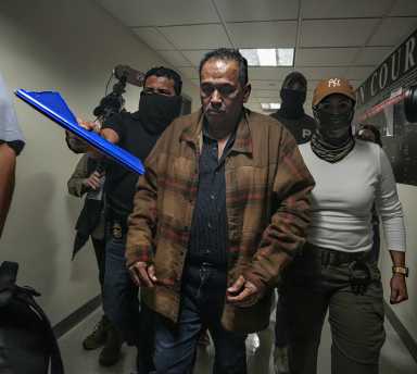 man detained by ICE in court as people look on