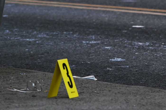 A pair of glasses lays on the ground near an evidence marker.