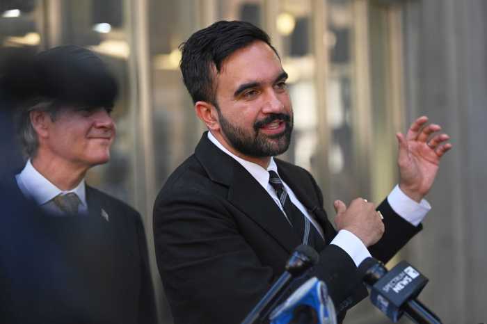 mamdani clapping hands at press event