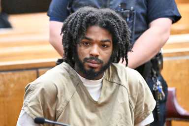 Suspect seated while handcuffed for Lower East Side naked rampage in which he attacked cops