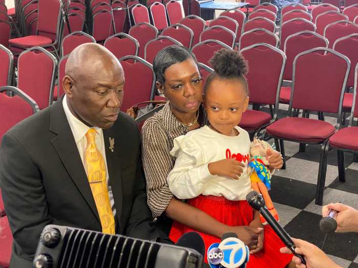 Lakisha Plowden, holding her 6-year-old daughter Brooke, speaks alongside attorney Ben Crump during a press conference at the House of Justice in Harlem on Sept. 23