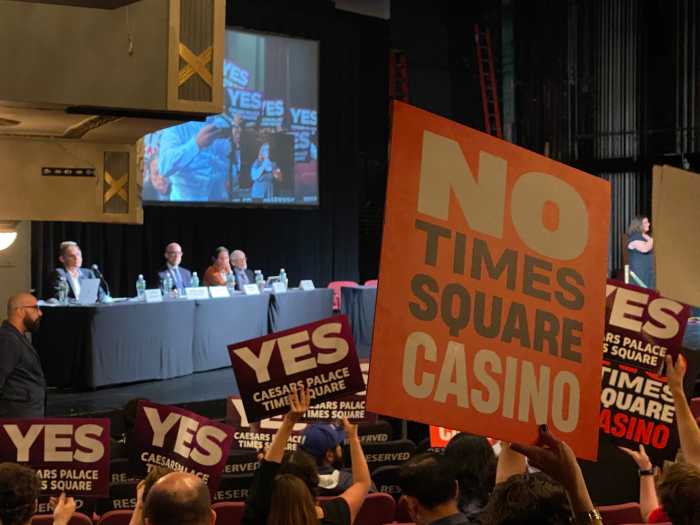 Supporters and critics of the Times Square casino project vie for visibility with competing signs at the last public hearing on Thursday.