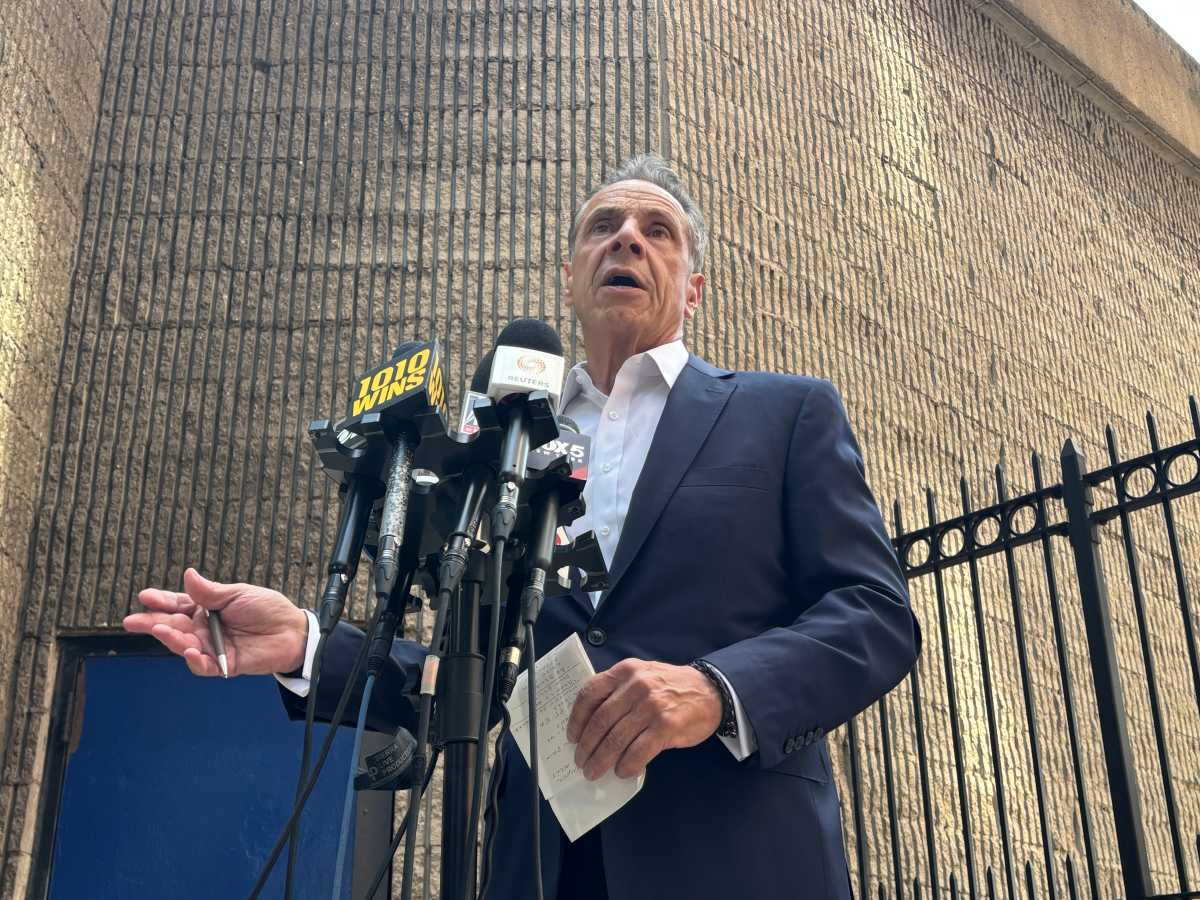 Andrew Cuomo speaking to press before microphones at press conference amid mayor's race