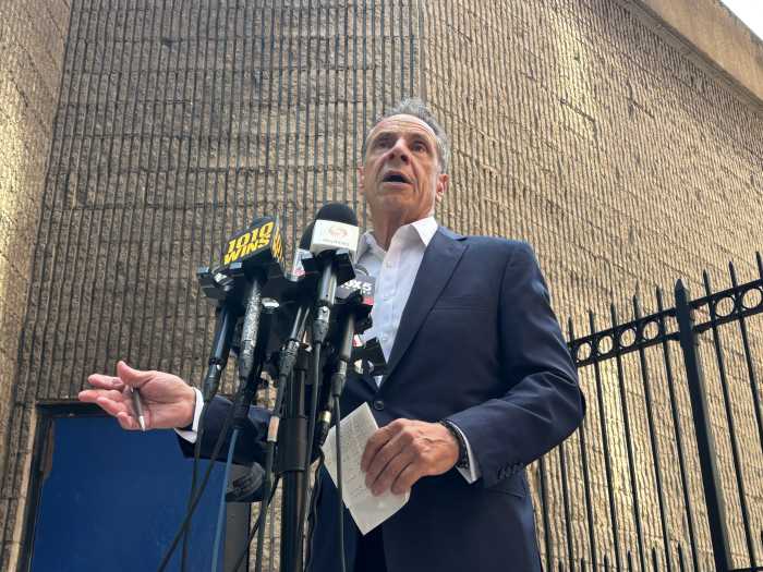 Andrew Cuomo speaking to press before microphones at press conference amid mayor's race