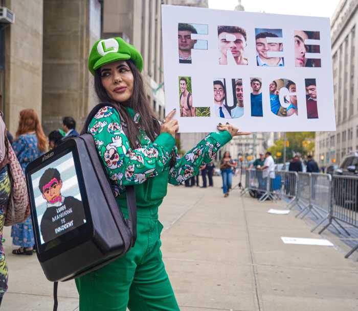 supporter of Luigi Mangione holds up sign outside court