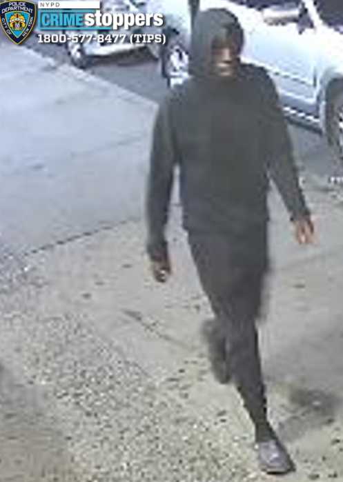 man wearing all black walking on a sidewalk