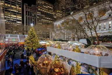 Cozy Igloos with the Christmas Tree at Bank of America Winter Village at Bryant Park NYC.