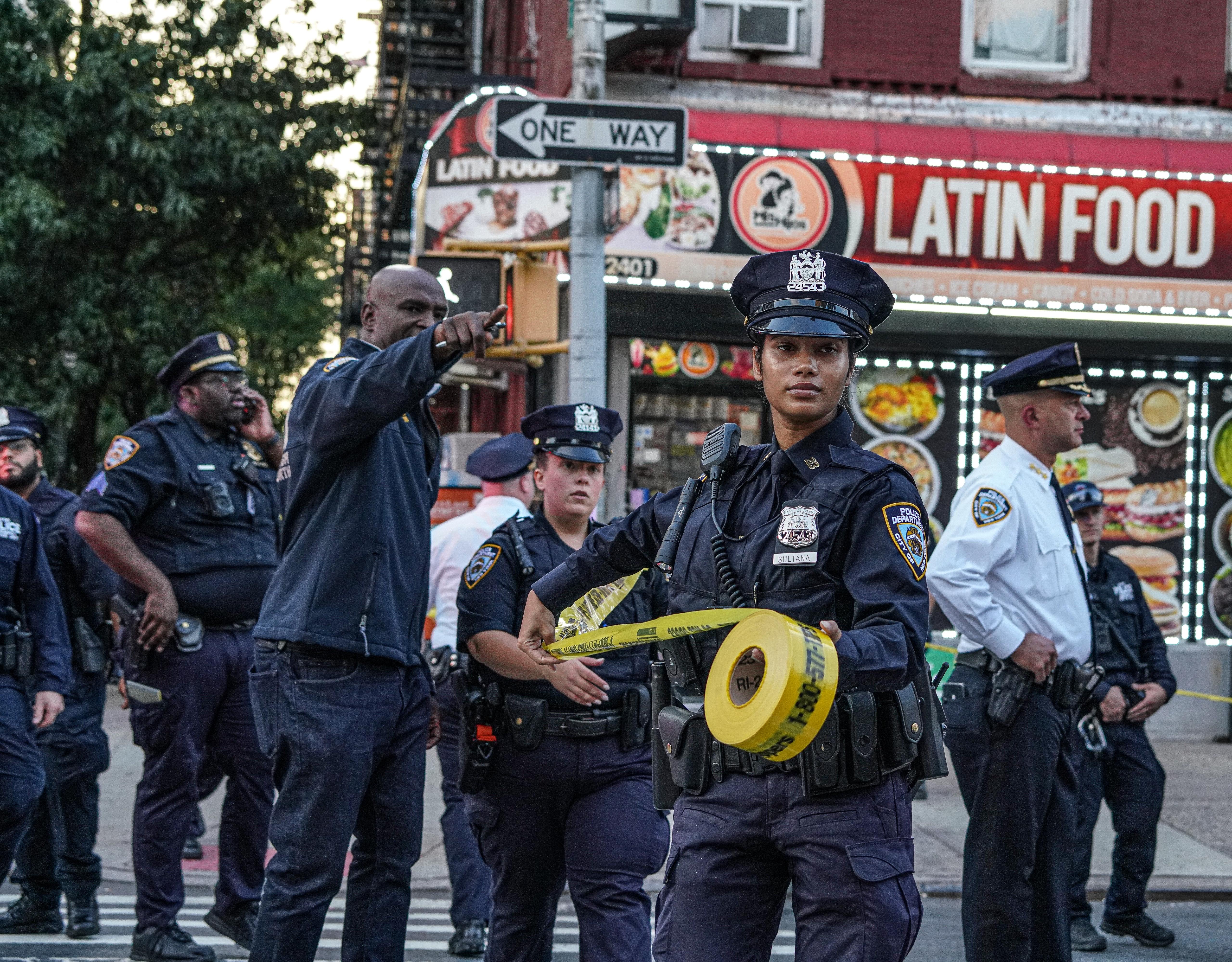 Police set up crime scene tape at scene of Harlem shooting