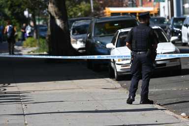 police officer stands at scene where man was shot