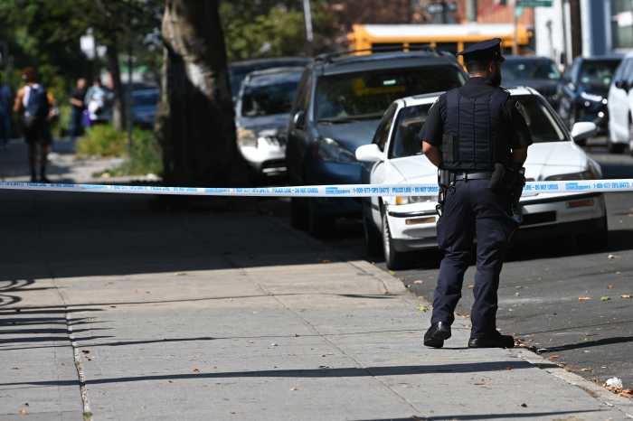 police officer stands at scene where man was shot