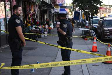 police officers and crime scene tape at scene of Brooklyn shooting