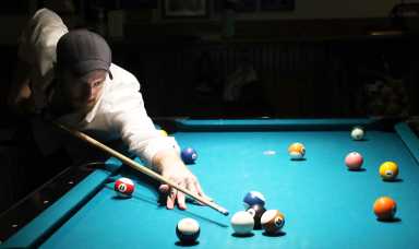 Man plays billiards on pool table found through Chalkysticks
