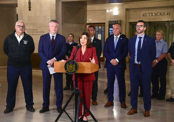 people in suits at a podium inside a train station