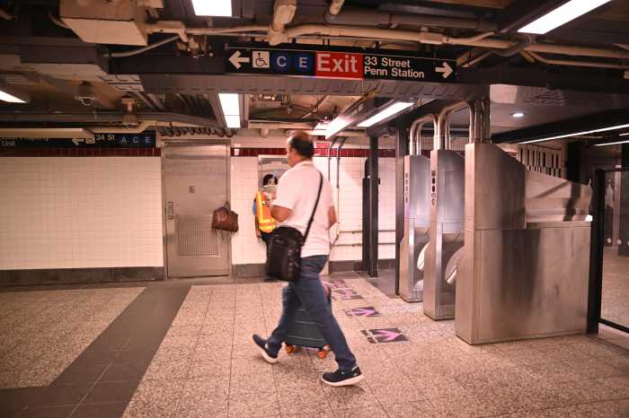 man walking in a subway station as a guard stands nearby