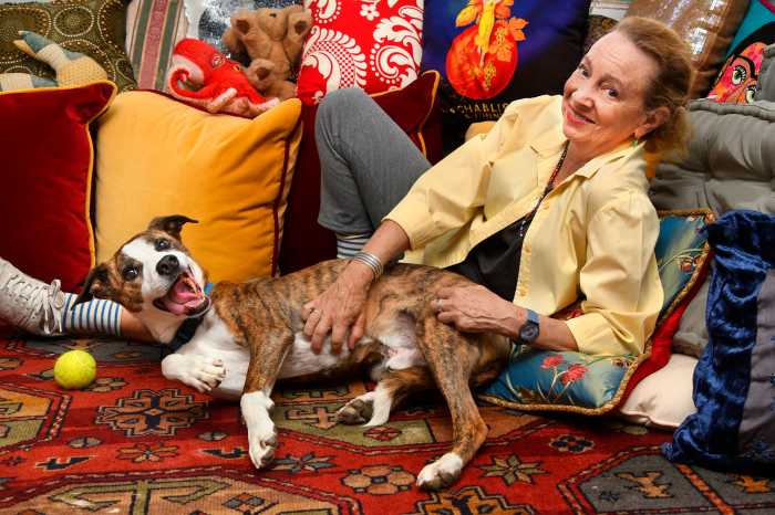 Jamie Bernstein at home lying down while petting her pet dog