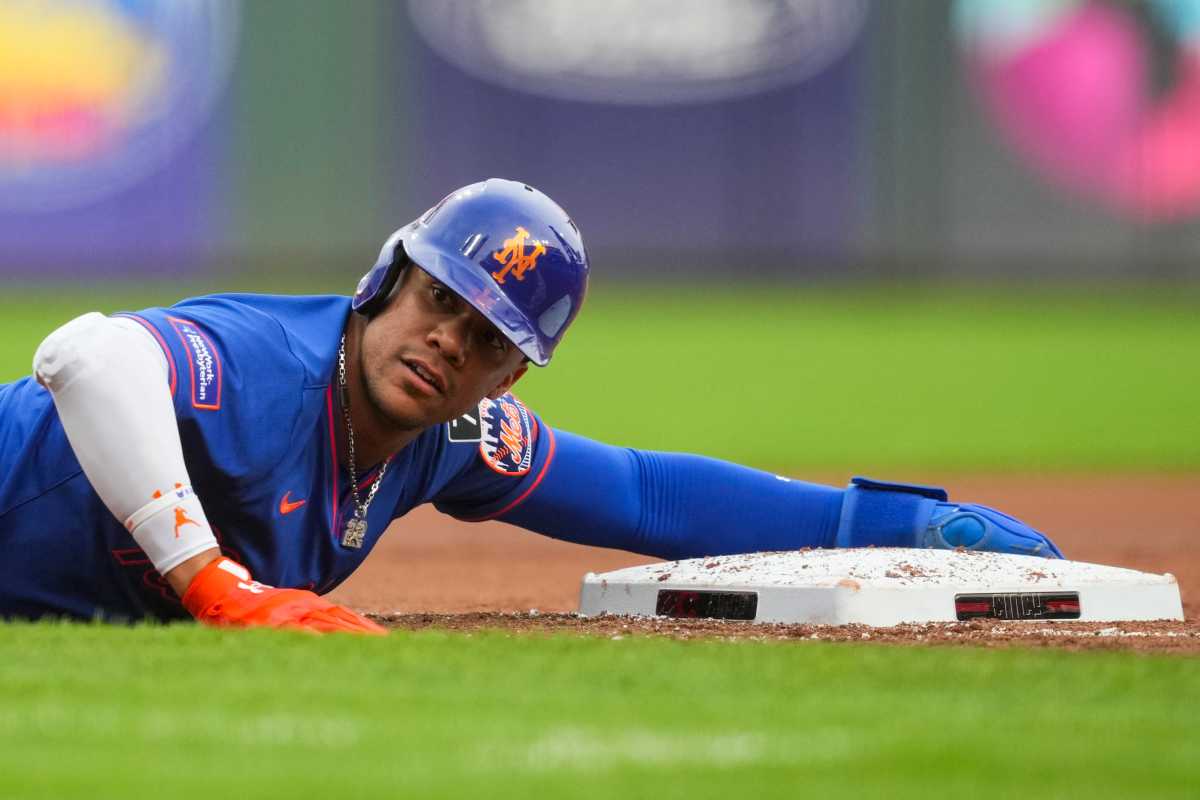 Juan Soto Mets: Baseball player in blue uniform holds on to third base bag.