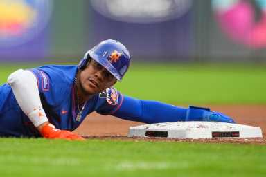Juan Soto Mets: Baseball player in blue uniform holds on to third base bag.