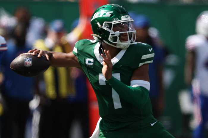 Justin Fields Jets Bills: Man in green football uniform winds up to throw football