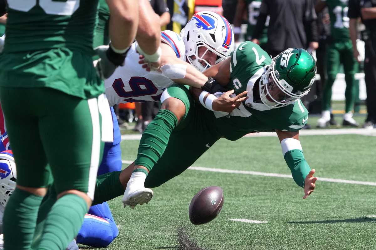 Jets player tackled to the turf dropping football