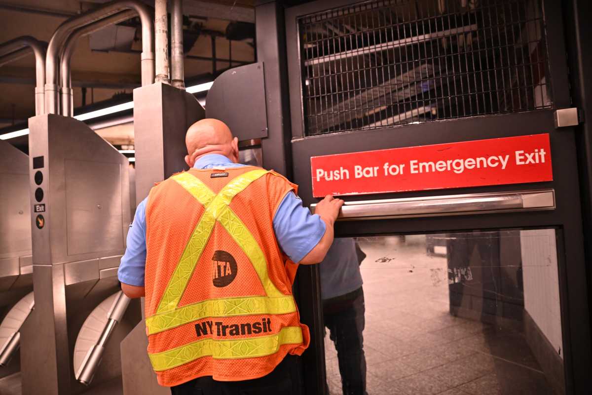 man wearing an orange vest at subway gates