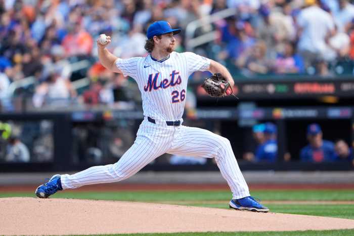 Nolan McLean Mets Rangers: Man in white baseball uniform delivers pitch toward home plate.