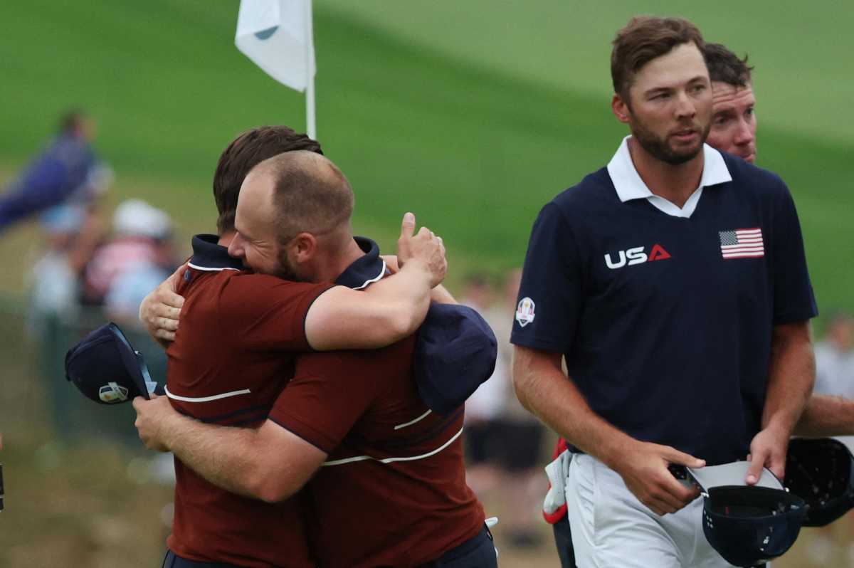 Team Europe's Matt Fitzpatrick and Tyrrell Hatton celebrates after winning the match on the 18th hole during the four-balls as Team USA's Sam Burns looks on.