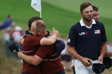 Team Europe's Matt Fitzpatrick and Tyrrell Hatton celebrates after winning the match on the 18th hole during the four-balls as Team USA's Sam Burns looks on.