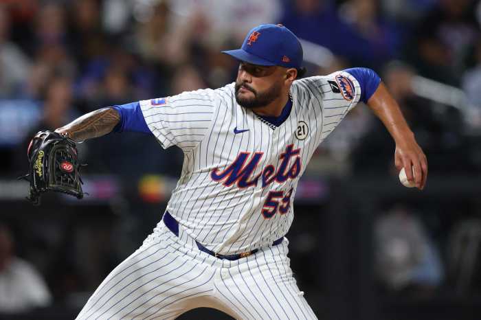 Sean Manaea Mets Padres: Man in white baseball uniform winds up to throw pitch
