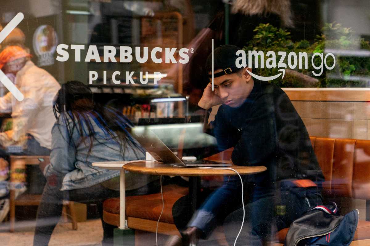 Man in Starbucks cafe reading laptop