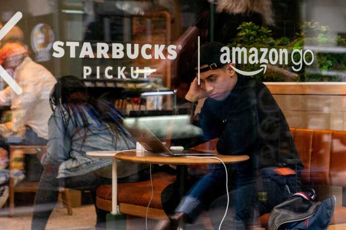 Man in Starbucks cafe reading laptop