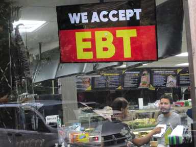 A sign in the window of a grocery in Chelsea in New York announces that the convenience store accepts SNAP EBT (electronic benefit transfer) funds, seen on Monday, July 29, 2024.
