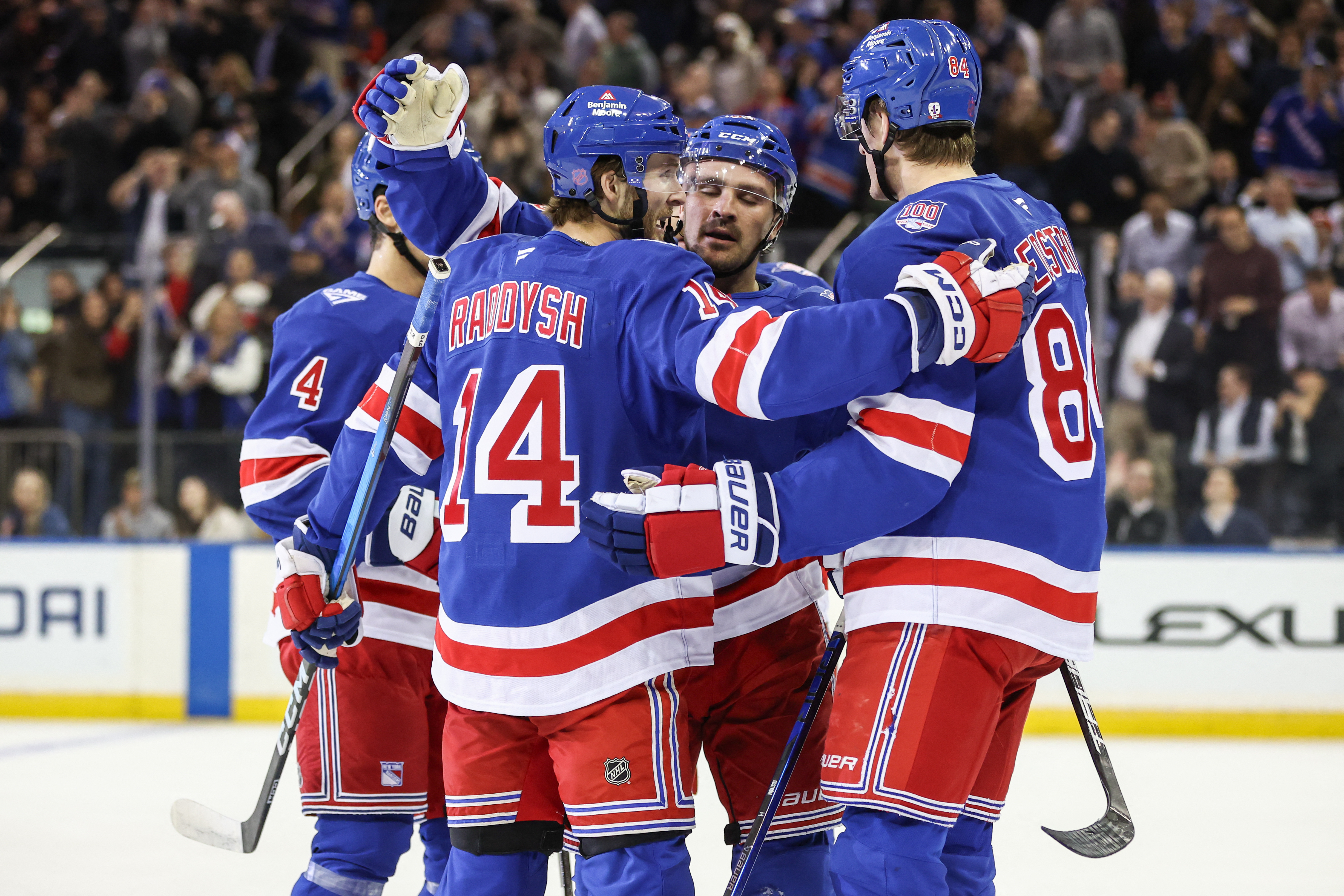 Oct 23, 2025; New York, New York, USA; New York Rangers right wing Taylor Raddysh (14) celebrates with his teammates after scoring a goal in the first period against the San Jose Sharks at Madison Square Garden.