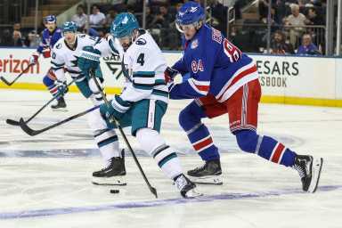 San Jose Sharks defenseman Nick Leddy (4) and New York Rangers center Adam Edstrom (84) battle for control of the puck in the first period at Madison Square Garden.