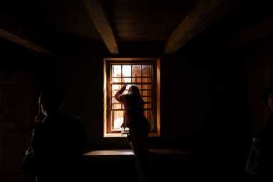 a woman looks out a window in a dark room