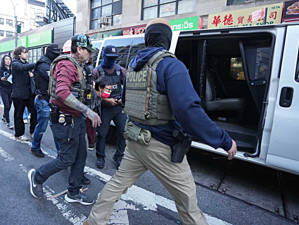 ICE agents lead arrested man into van