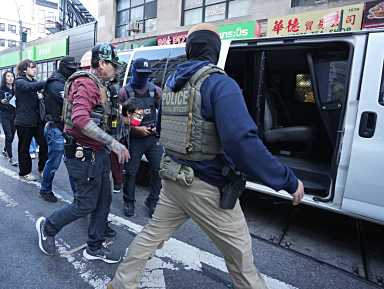 ICE agents lead arrested man into van