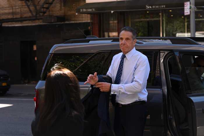 Andrew Cuomo exiting vehicle while putting jacket on