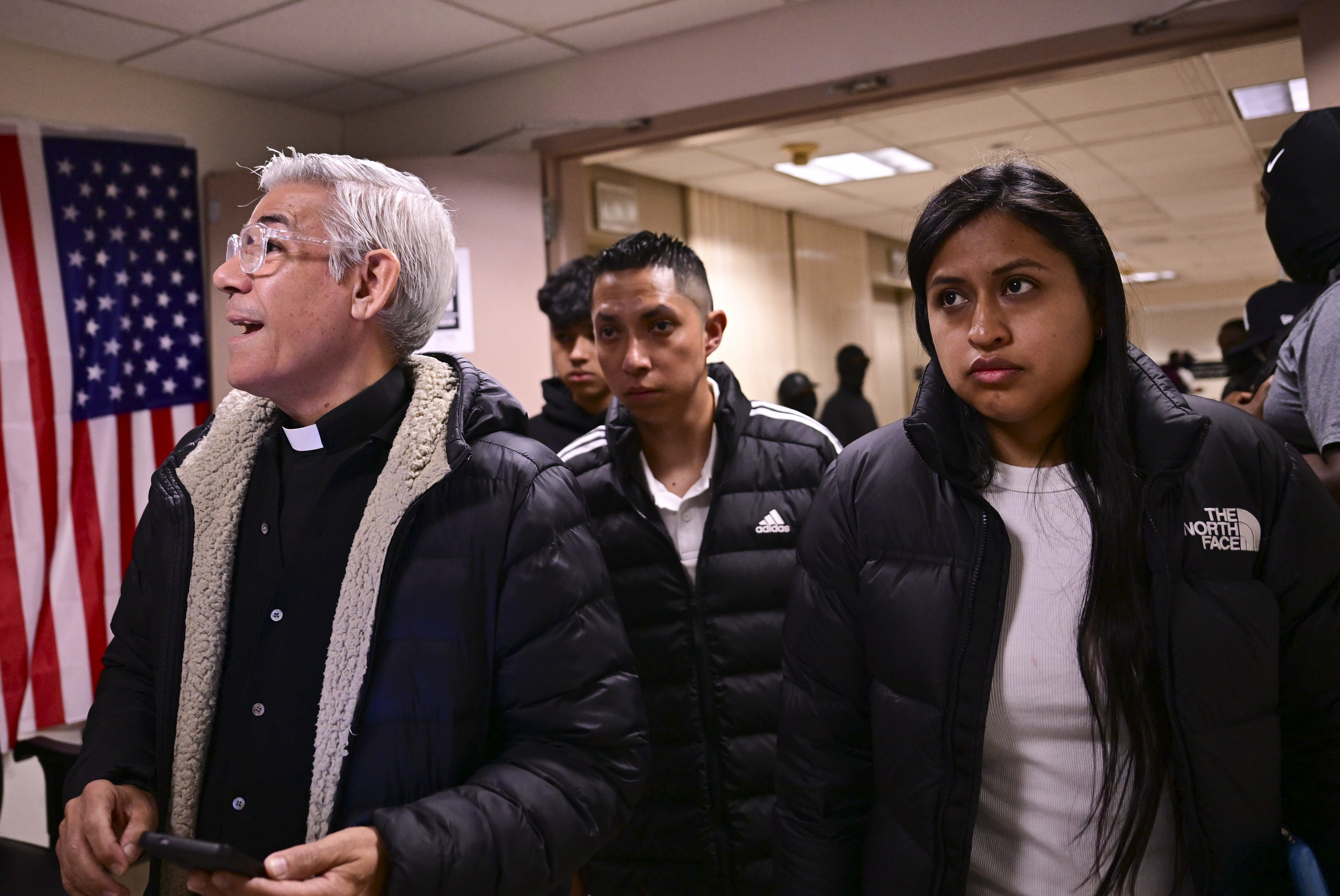Local Pastor Fabian Arias escorts migrants in Federal Hall.