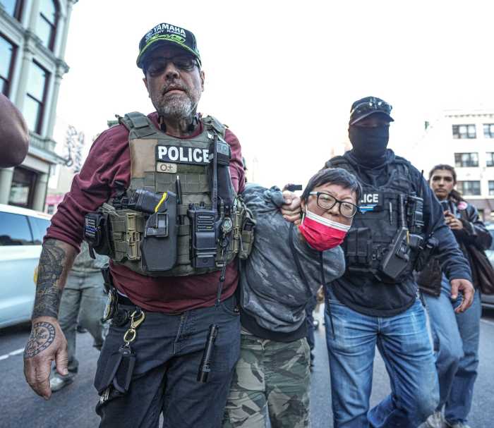ICE agents haul away a protester at Chinatown raid
