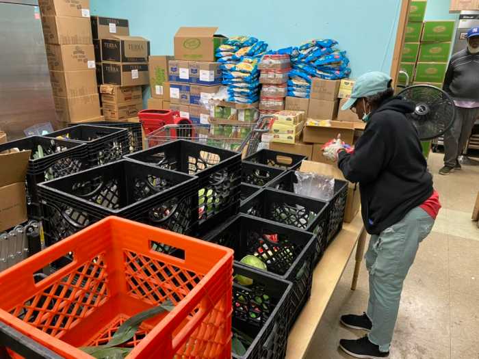 Yvette Odom, who has volunteered at the Bowen Center for 30 years, prepares food packages for Harlem residents