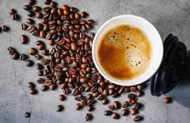 Coffee crema espresso in paper Coffee cup and bean on gray background, Top view of Espresso in Takeaway paper coffee cup