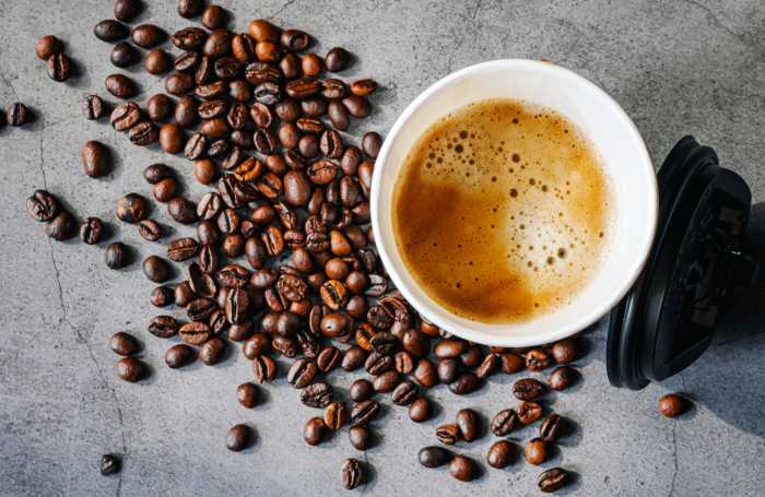 Coffee crema espresso in paper Coffee cup and bean on gray background, Top view of Espresso in Takeaway paper coffee cup