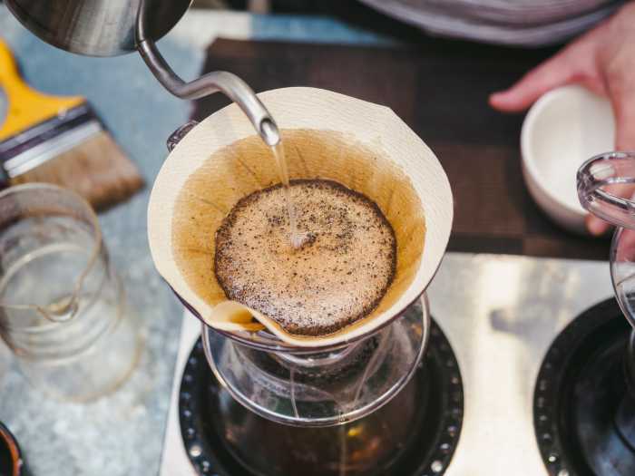 Hipster Barista making hand drip Coffee pouring water on filter Bar Cafe