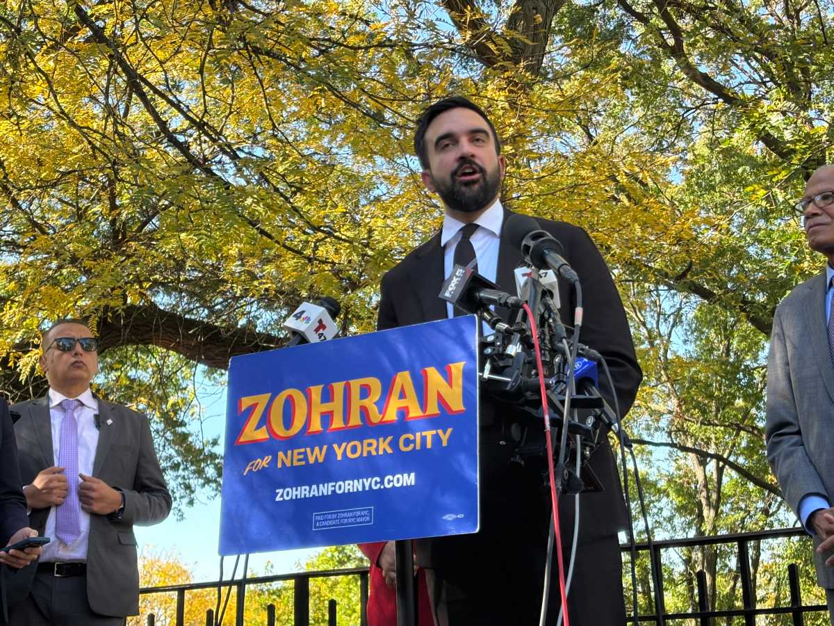 man zohran mamdani speaking at podium on education reform