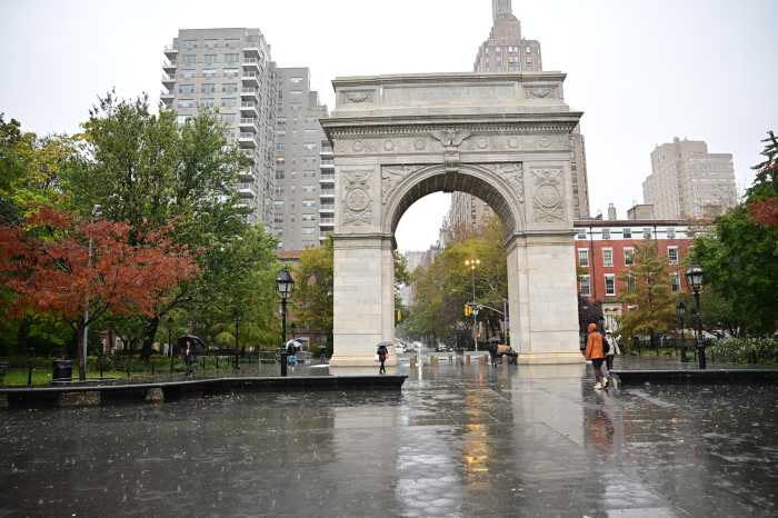 Washington Square Park drug market dismantled; five arrests linked to overdose death of Robert De Niro’s grandson 3 people walking through a rainy washington square park