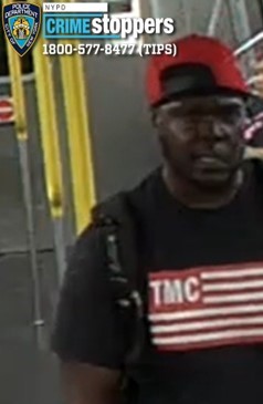 man in a red hat and black shirt with the letters "TMC"