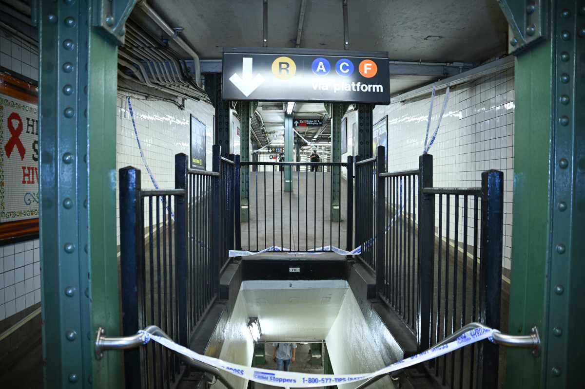 Police tape covers staircase to Brooklyn subway station where man was murdered.