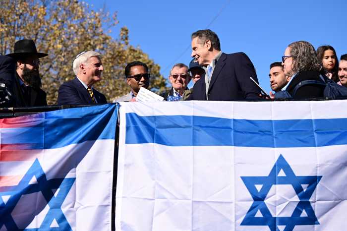 Cuomo stumps in Queens to rally with Jewish New Yorkers in support of Israel 2 people holding up the flag of Israel
