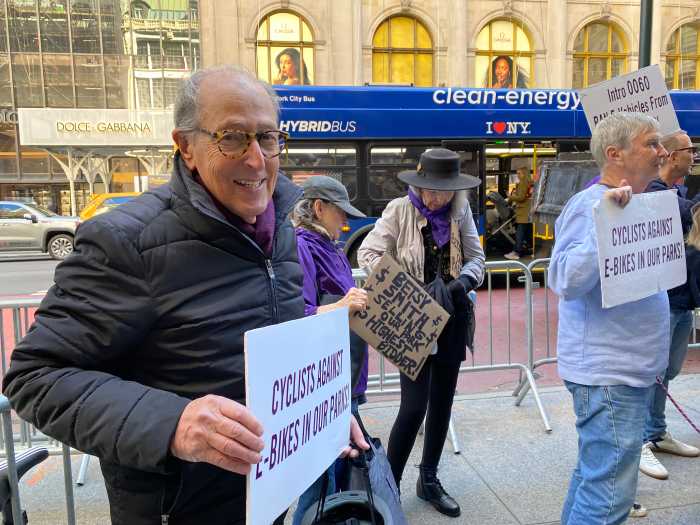 Central Park chaos: Safety advocates demand end to 'e-bike expressway' in NYC parks 2 people holding signs on a city street during the day